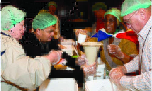 Conference participants pack 100,000 meals for children